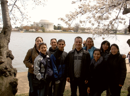 Lab members stand under cherry blossoms in front of the Tidal Basin in Washington DC. The Jefferson Memorial is in the background.