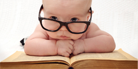 baby in glasses on top of book