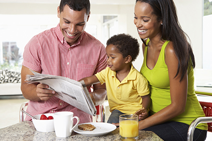 Parents and toddler reading newspaper