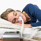 a woman sleeping with a CPAP mask