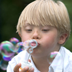 Boy with Down Syndrome blowing bubbles