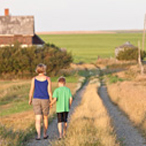 A mother and son walking down a rural road.