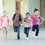 Group of elementary age schoolchildren running outside