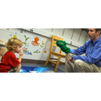 Indiana University researcher Isaac Petersen plays a puppet game with a toddler as part of a study on language skills.