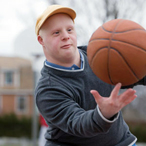 Boy with Down Syndrome playing basketball