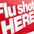 A sign advertises flu vaccines, with the words 'Flu Shots HERE!'