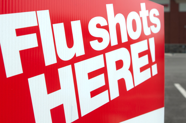 A sign advertises flu vaccines, with the words 'Flu Shots HERE!'