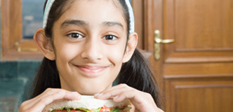 Young girl holding up a sandwich.