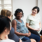 Pregnant woman talking to a group of pregnant women.