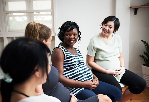 Stock image of a pregnant woman talking.