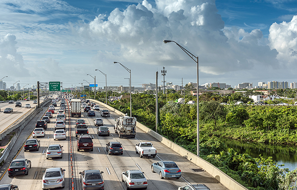 A busy highway with highrise buildings on the horizon.