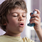 Child preparing to use an asthma inhaler.