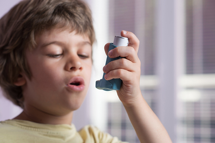 Child preparing to use an asthma inhaler.