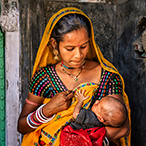 A young Indian mother breastfeeding her newborn baby.