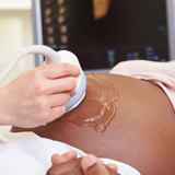 Pregnant woman lying on table getting an ultrasound 