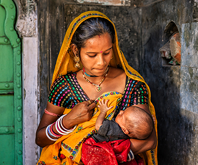 A young Indian mother breastfeeding her newborn baby.