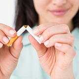 Woman holding unlit cigarette that has been broken in half 