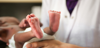 A healthcare worker holding a newborn.