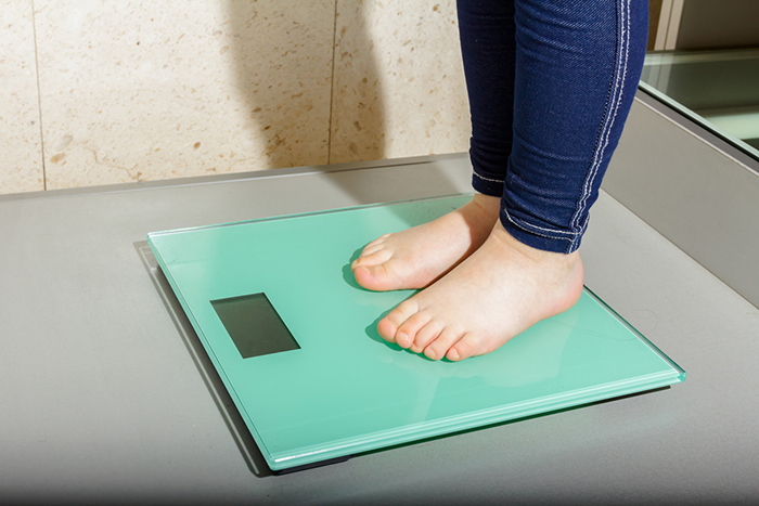 A child’s feet on a bathroom scale.