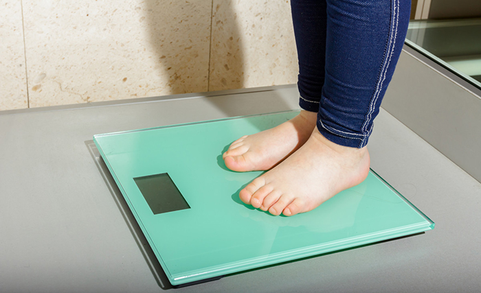 Child’s feet on a bathroom scale.