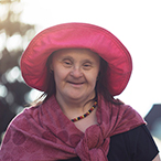 Older woman with Down syndrome, holding the hand of a younger woman.