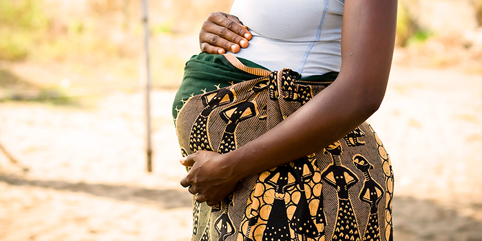 A pregnant woman with hands on her abdomen