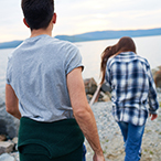 Woman walking away from man, both face away from the camera.