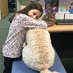 Girl hugs dog.