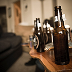 Multiple empty beer bottles on a coffee table.