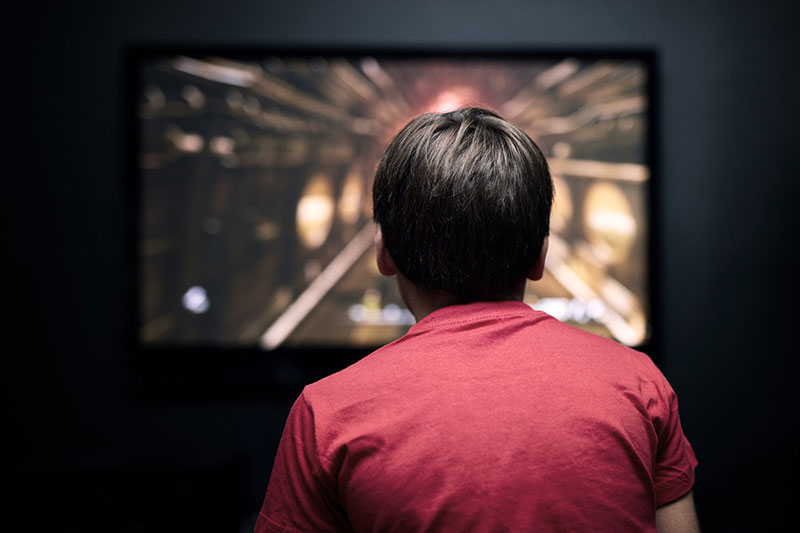 Child in front of a television screen.