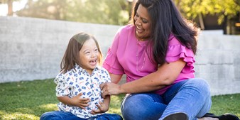 Mother smiling while playing with her son, who has Down syndrome.