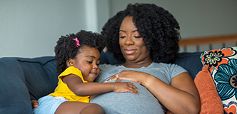 African American pregnant mother and her daughter.