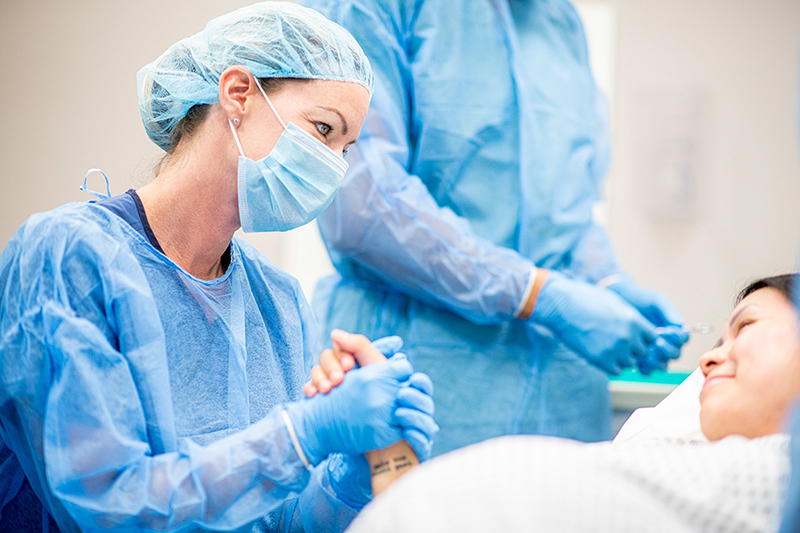 Pregnant woman comforted by health provider.