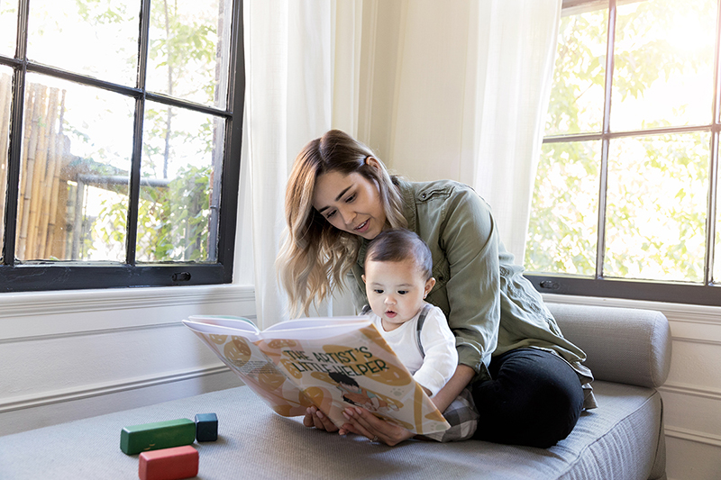 Woman and infant looking at picture book.