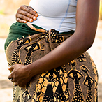 A pregnant person holding their abdomen.