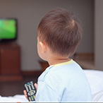 Seated child facing television screen, back to camera.