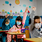 Elementary school children wearing face masks in the classroom.