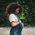 Pregnant person holding her abdomen.