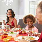 A diverse, multi-generational family shares a Thanksgiving meal.