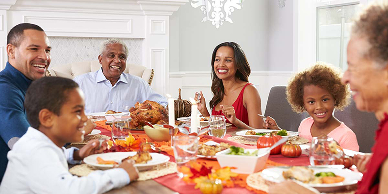 A diverse, multi-generational family shares a Thanksgiving meal.