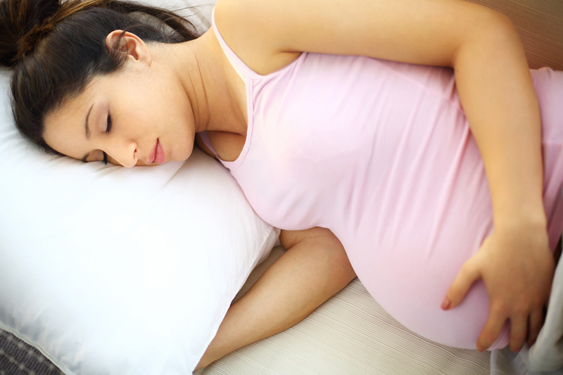 Pregnant person sleeping on their side.