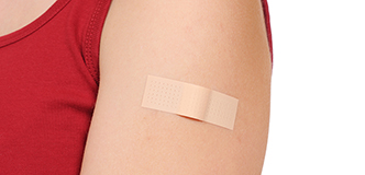 Person’s shoulder with a bandaid.