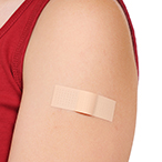 Person’s shoulder with a bandaid.