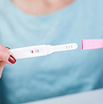 Hands holding a pregnancy test stick.