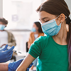 Medical professional giving an injection in a child’s arm.