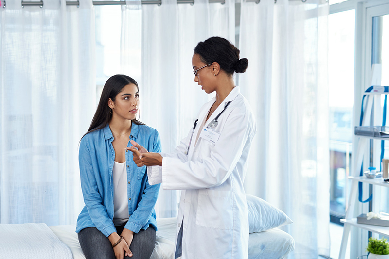 A woman speaks with her healthcare provider during a checkup.