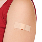 Shoulder with bandaid, presumably covering injection site.