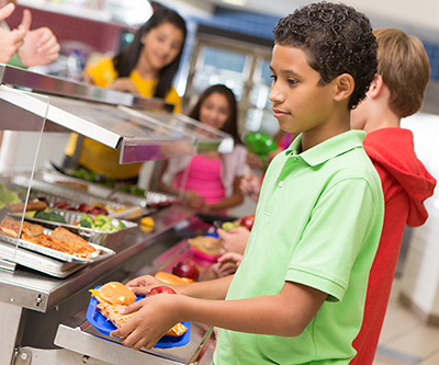 Children make their meal selections during school lunch.