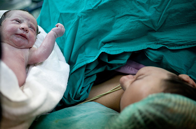 A newborn is presented to their mother immediately after delivery.