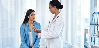 A woman speaks with her healthcare provider during a checkup.